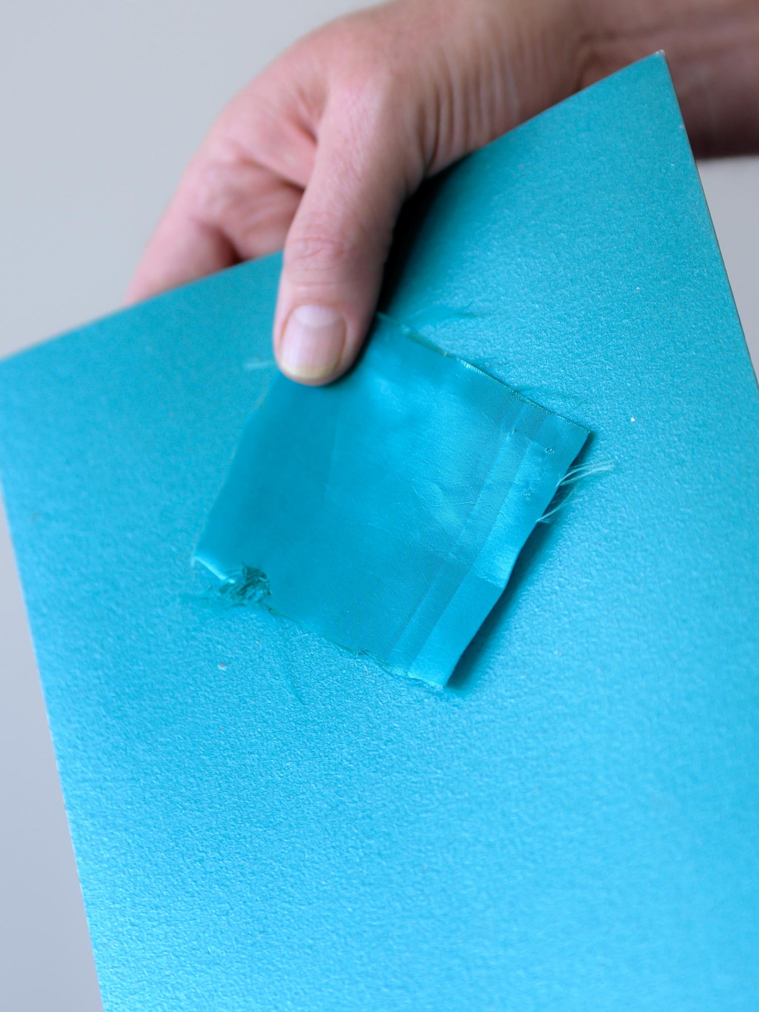 Teal fabric compared directly with a painted custom color sample